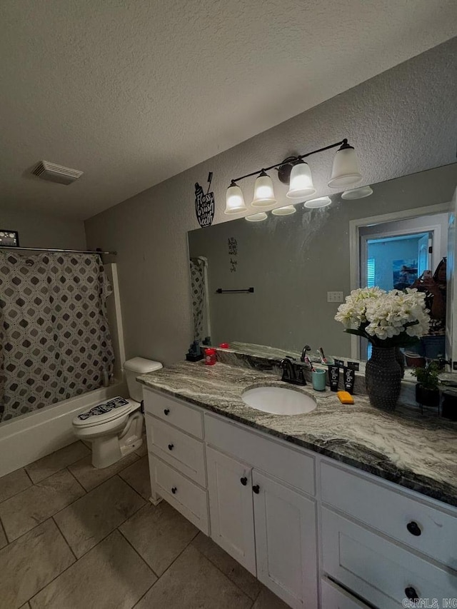 full bathroom with tile patterned floors, toilet, a textured ceiling, vanity, and shower / tub combo