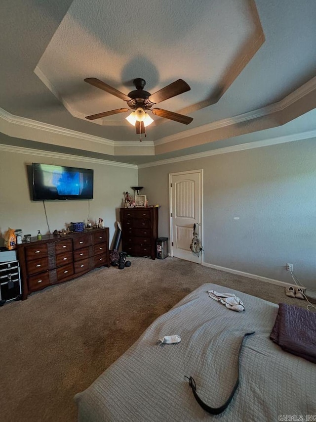 carpeted bedroom featuring ceiling fan, a tray ceiling, and ornamental molding