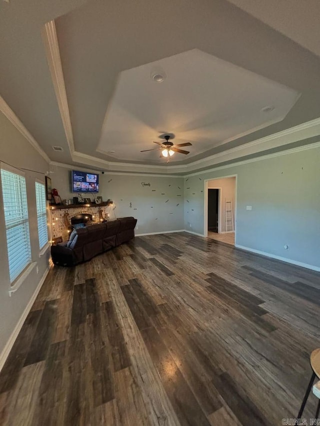 unfurnished living room with ceiling fan, hardwood / wood-style flooring, crown molding, and a tray ceiling