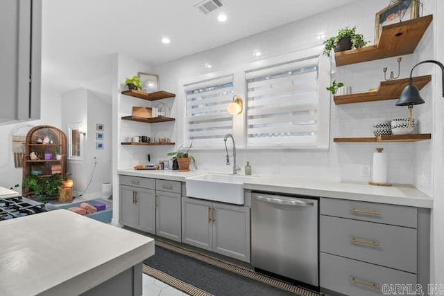 kitchen featuring sink, dishwasher, gray cabinets, and backsplash