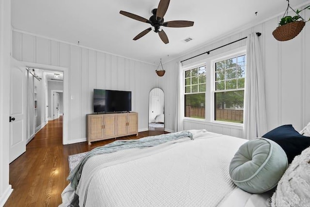 bedroom featuring ceiling fan, dark hardwood / wood-style flooring, and crown molding