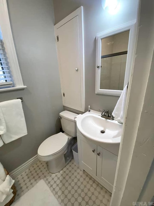 bathroom with toilet, tile patterned floors, and vanity