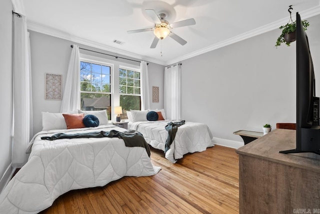 bedroom with ceiling fan, crown molding, and light hardwood / wood-style floors