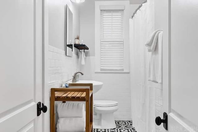 bathroom featuring toilet, walk in shower, and tile patterned floors