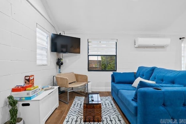 living room featuring hardwood / wood-style flooring, an AC wall unit, vaulted ceiling, and crown molding