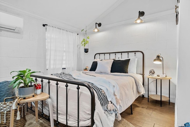 bedroom featuring lofted ceiling, hardwood / wood-style floors, and a wall mounted air conditioner