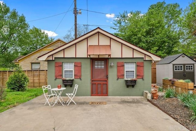 rear view of house featuring a patio area and an outbuilding