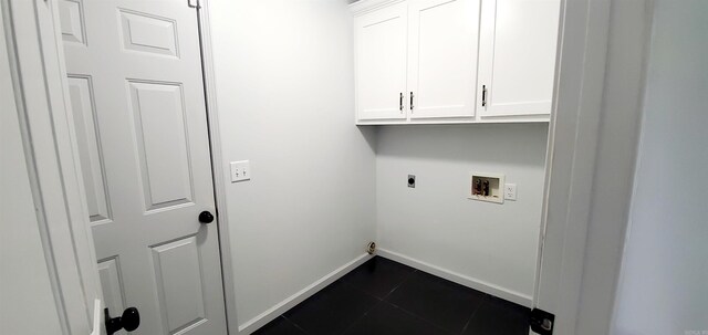 laundry area featuring dark tile patterned flooring, electric dryer hookup, washer hookup, and cabinets