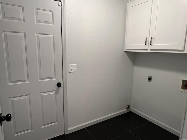 laundry room featuring hookup for a washing machine, cabinet space, hookup for an electric dryer, dark tile patterned flooring, and baseboards