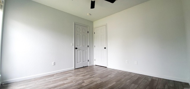 empty room featuring light wood-style flooring, baseboards, and a ceiling fan