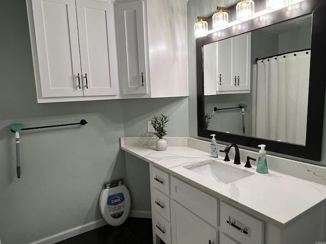 full bath with vanity and baseboards