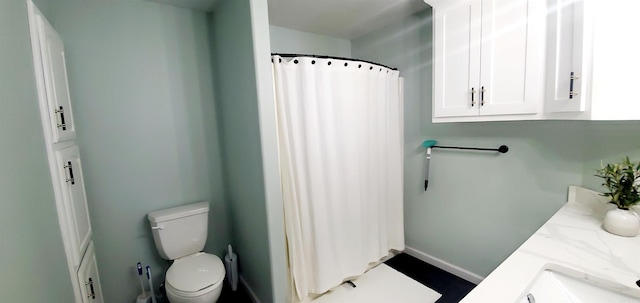 bathroom with toilet, a shower with curtain, baseboards, and vanity