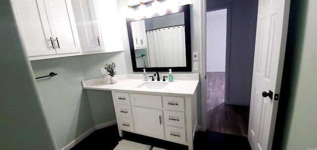 bathroom with vanity, baseboards, and wood finished floors