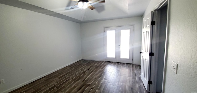 empty room featuring wood tiled floor, baseboards, a ceiling fan, and french doors