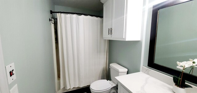 full bathroom with toilet, shower / bathtub combination with curtain, and vanity