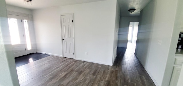 foyer entrance featuring dark wood finished floors and baseboards