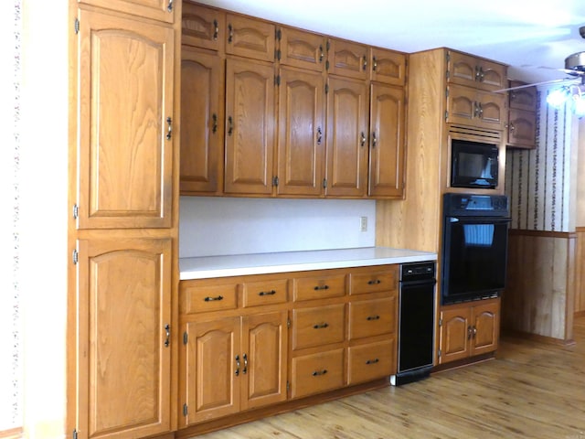 1105 Crescent Dr, Mena, AR 71953 - kitchen with black appliances, brown cabinetry, light wood-style floors, light countertops, and ceiling fan