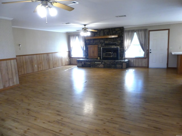 unfurnished living room featuring ceiling fan, crown molding, dark hardwood / wood-style flooring, and a fireplace