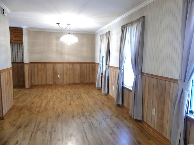 1105 Crescent Dr, Mena, AR 71953 - unfurnished dining area with wallpapered walls, light wood-type flooring, a wainscoted wall, ornamental molding, and wooden walls