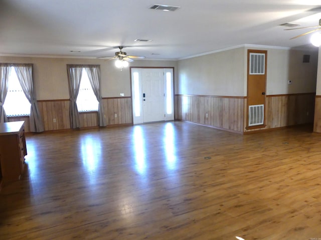 empty room with ceiling fan, dark wood-type flooring, and crown molding