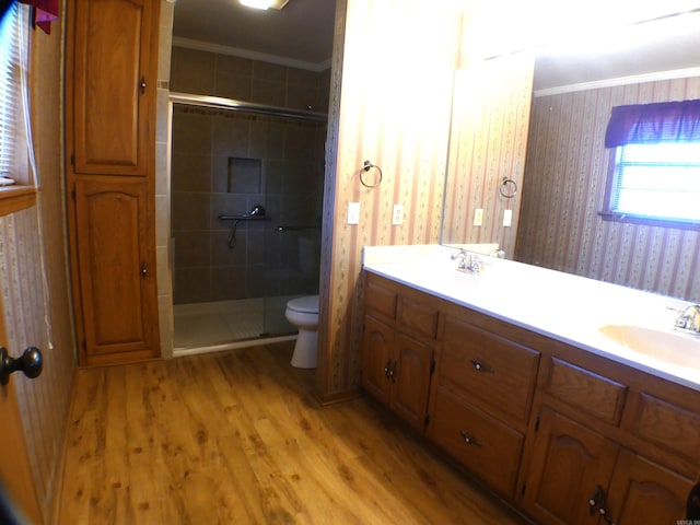 1105 Crescent Dr, Mena, AR 71953 - bathroom with crown molding, toilet, a stall shower, wood finished floors, and double vanity