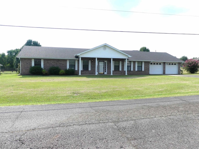 1105 Crescent Dr, Mena, AR 71953 - view of front of house with a garage, asphalt driveway, covered porch, a front yard, and brick siding