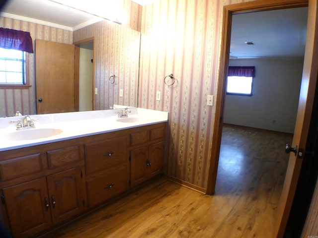 1105 Crescent Dr, Mena, AR 71953 - bathroom with wallpapered walls, wood finished floors, double vanity, ornamental molding, and baseboards