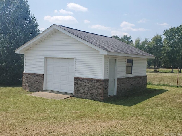 exterior space featuring a lawn, an outdoor structure, and a garage