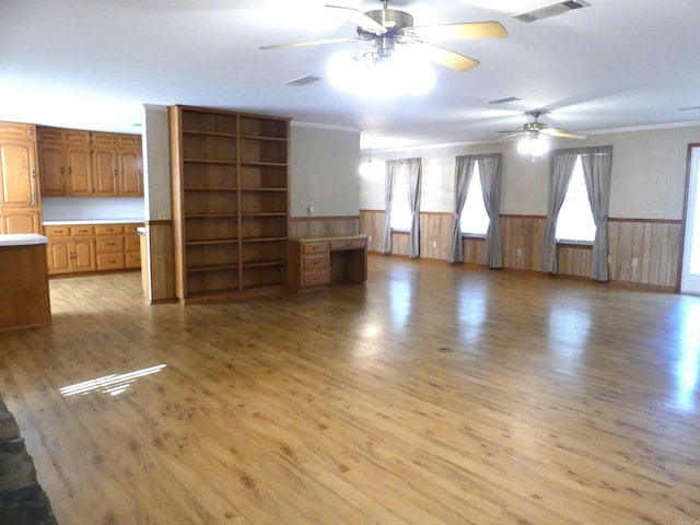 unfurnished living room featuring ceiling fan, light hardwood / wood-style floors, and ornamental molding