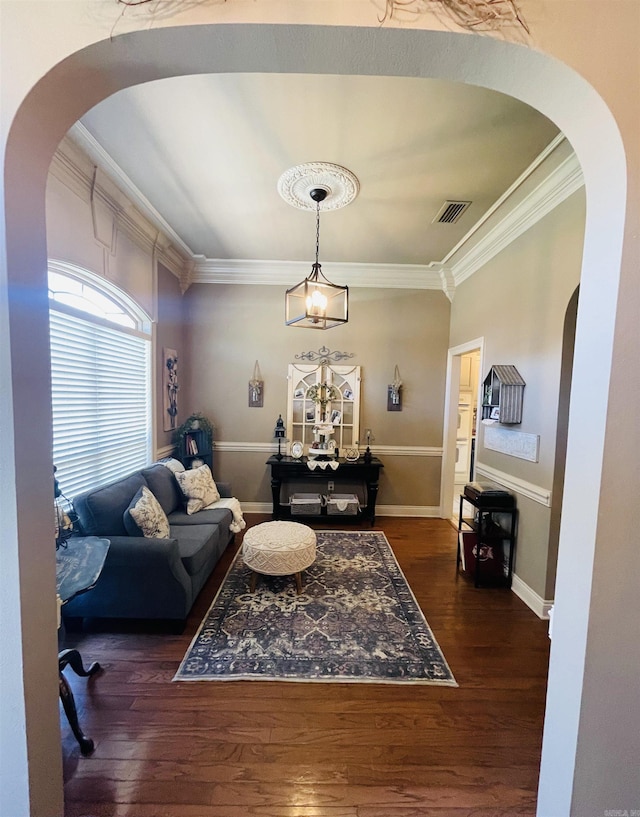 living room with arched walkways, visible vents, dark wood-style flooring, and crown molding