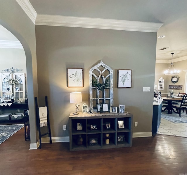 interior space featuring dark wood-style floors, arched walkways, visible vents, and crown molding