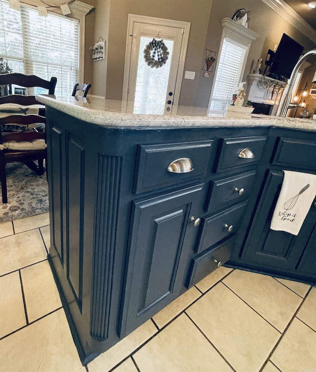 kitchen with blue cabinetry, light stone counters, and light tile patterned flooring