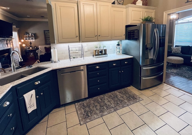 kitchen featuring tasteful backsplash, appliances with stainless steel finishes, ornamental molding, light tile patterned flooring, and a sink