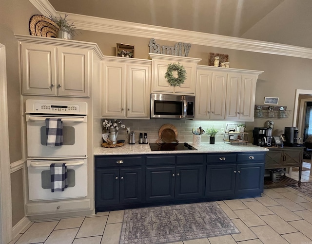 kitchen featuring double oven, black electric stovetop, white cabinets, light countertops, and stainless steel microwave