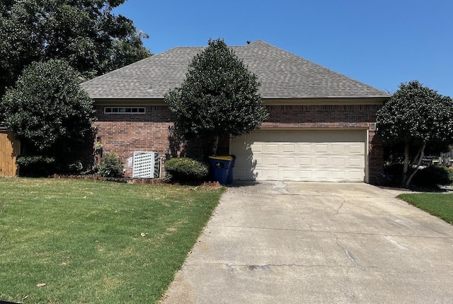 view of front facade with driveway, a garage, roof with shingles, a front lawn, and brick siding