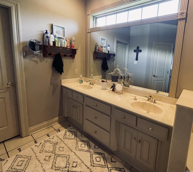 bathroom with double vanity, baseboards, a sink, and tile patterned floors