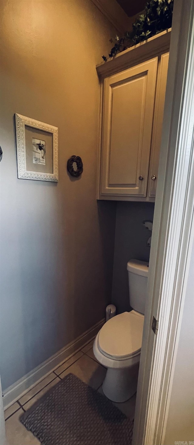 bathroom with tile patterned flooring, toilet, and baseboards