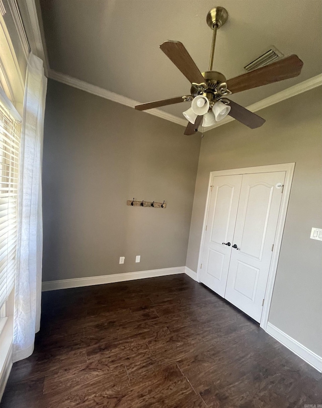 unfurnished bedroom with baseboards, visible vents, dark wood-type flooring, and crown molding