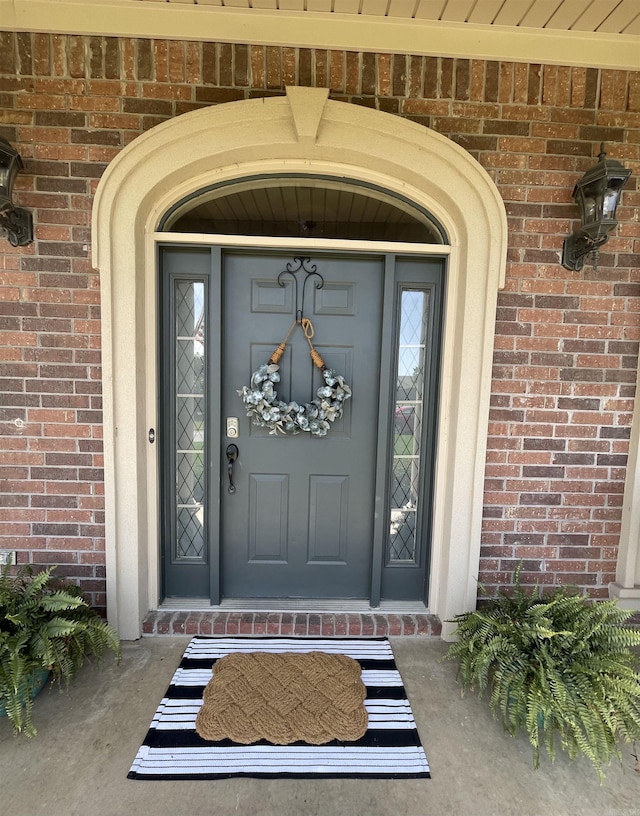 doorway to property featuring brick siding