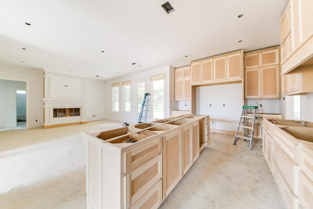 kitchen with a kitchen island and light brown cabinetry