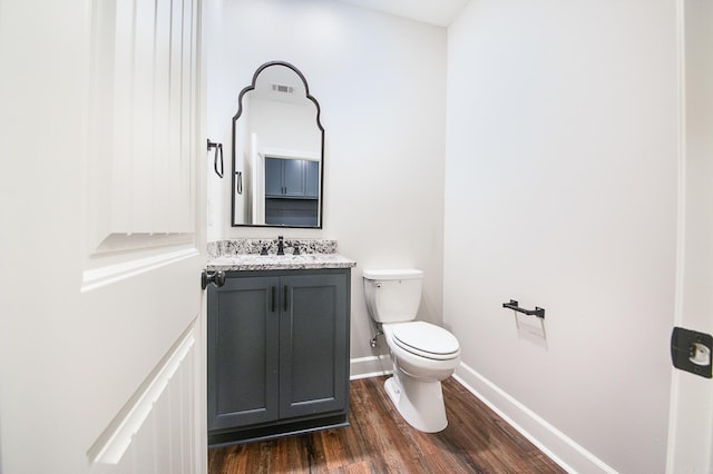 bathroom with hardwood / wood-style flooring, vanity, and toilet