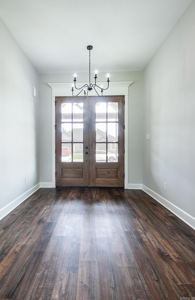 interior space featuring an inviting chandelier, dark wood-type flooring, and french doors