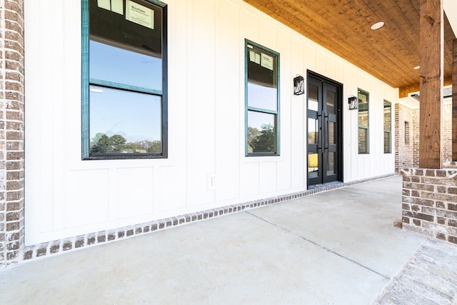 doorway to property with brick siding and board and batten siding