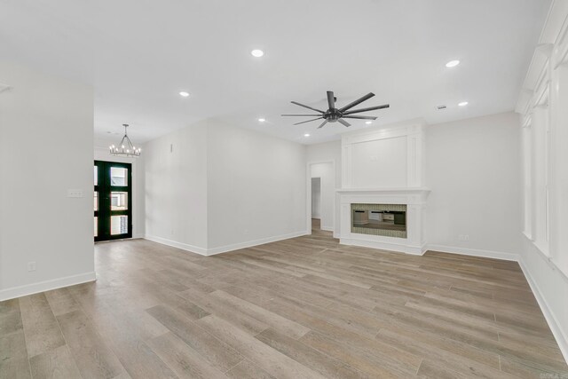 unfurnished living room with ceiling fan with notable chandelier, dark hardwood / wood-style flooring, and beamed ceiling