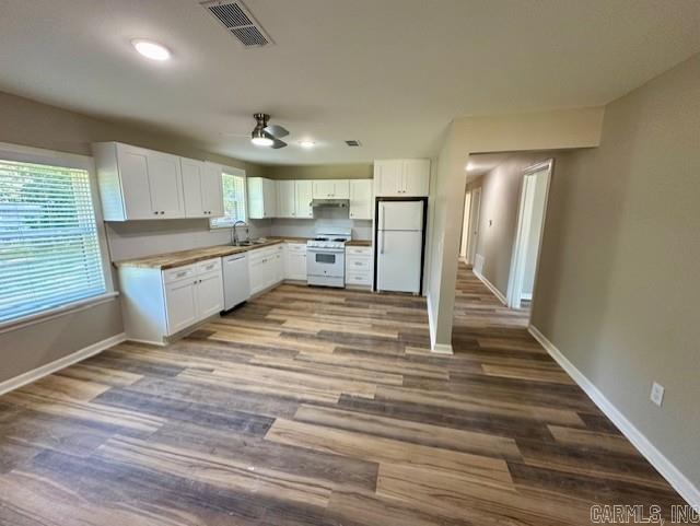 kitchen featuring hardwood / wood-style floors, white appliances, and white cabinets