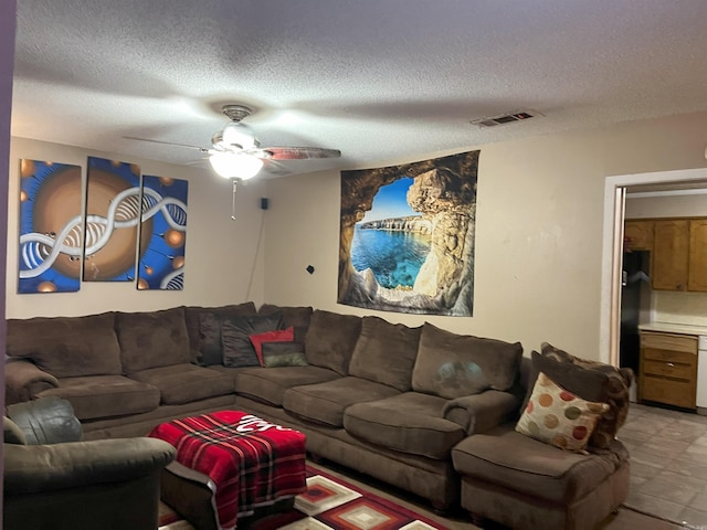 tiled living room with a textured ceiling and ceiling fan