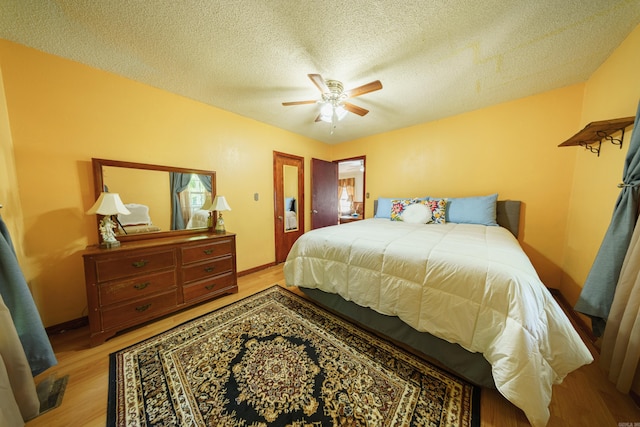 bedroom featuring a textured ceiling, ceiling fan, and light wood-type flooring