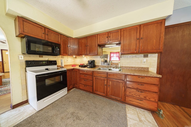 kitchen with light wood-type flooring, decorative backsplash, electric range, sink, and a textured ceiling