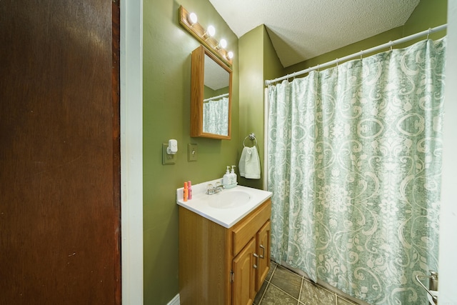 bathroom with tile patterned floors, a textured ceiling, vanity, and curtained shower