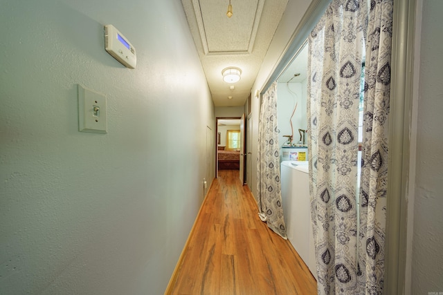 hallway featuring a textured ceiling and light hardwood / wood-style flooring